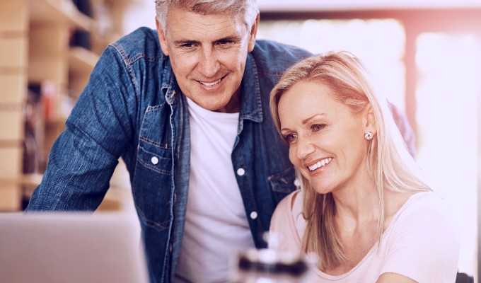 man and woman looking at laptop smiling
